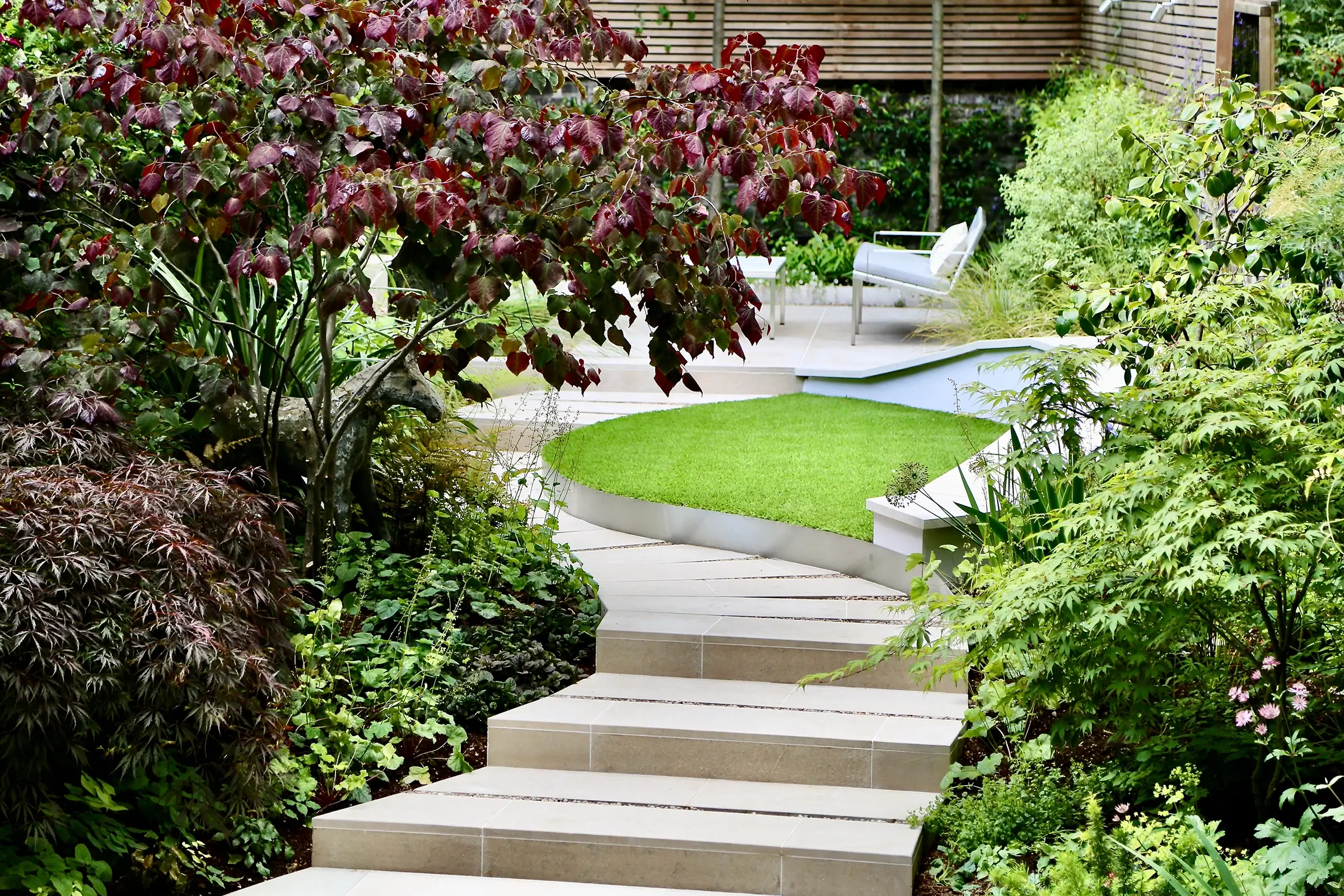 A shady London garden was with limestone paving and splashes of colour