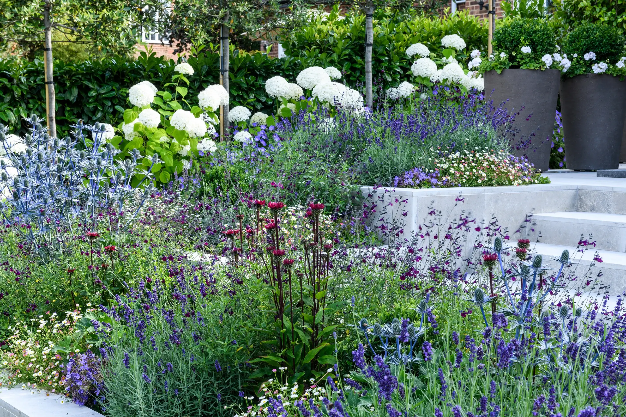 A garden that exudes classical formality, softened by romantic, billowy planting