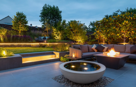 A stylish modern garden lit up by outdoor lighting at night